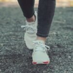 person in black leggings and white nike sneakers