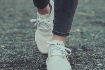person in black leggings and white nike sneakers