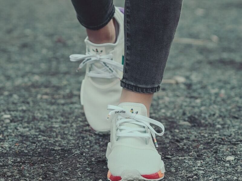 person in black leggings and white nike sneakers