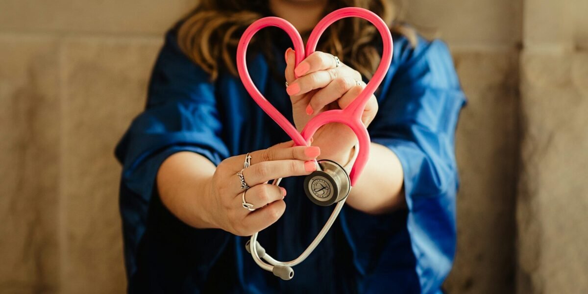 girl in blue jacket holding red and silver ring